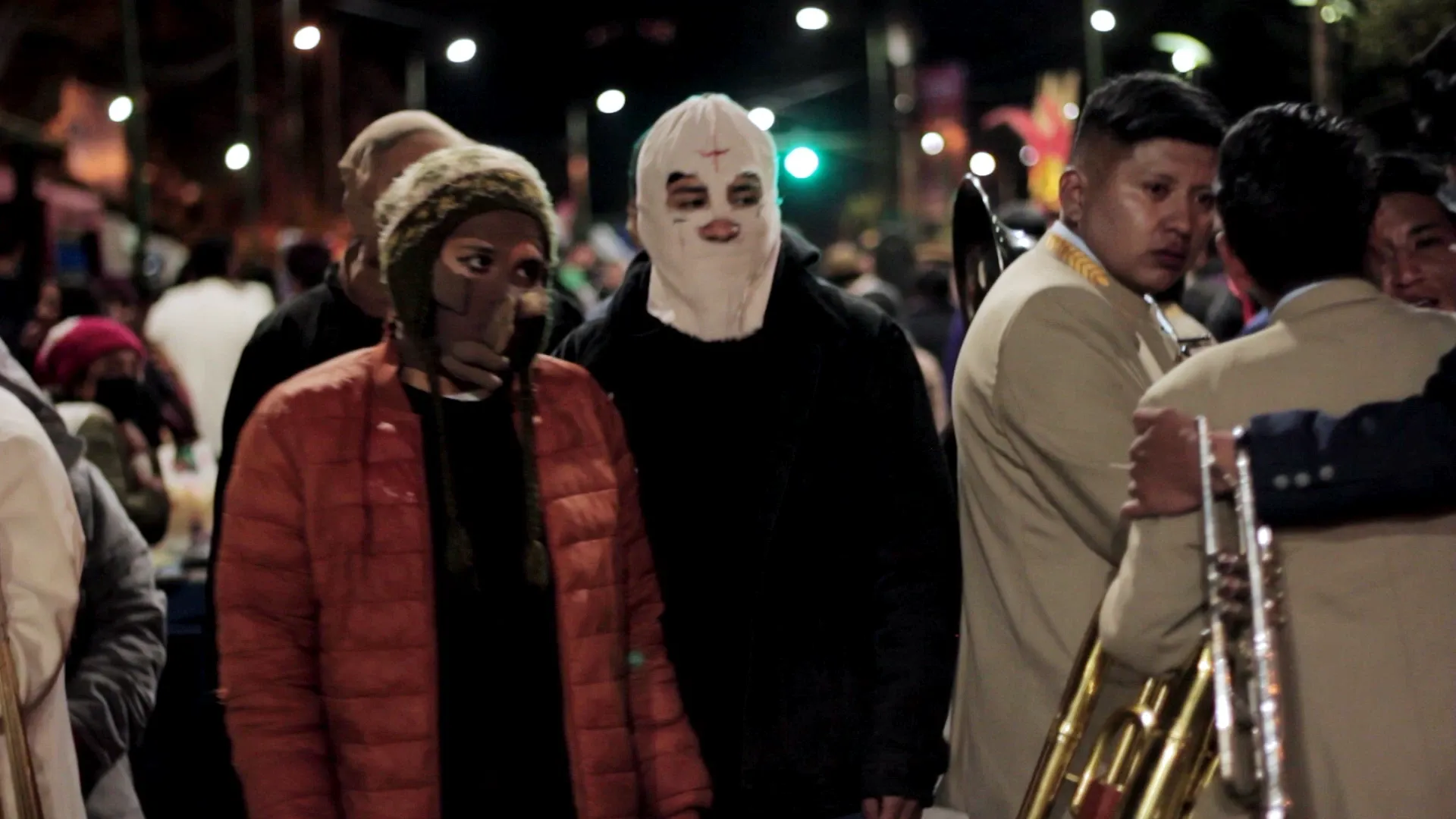 K'usillos enmascarados entre la banda en una calle nocturna de La Paz